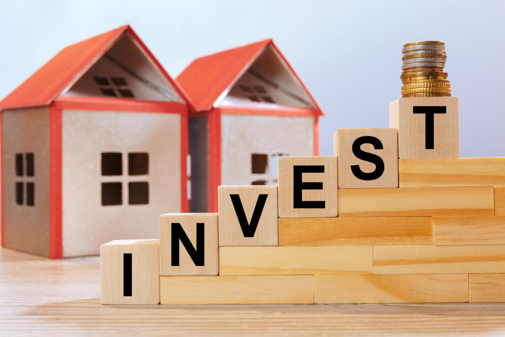 house models inscription wooden cubes invest real estate investment concept scaled