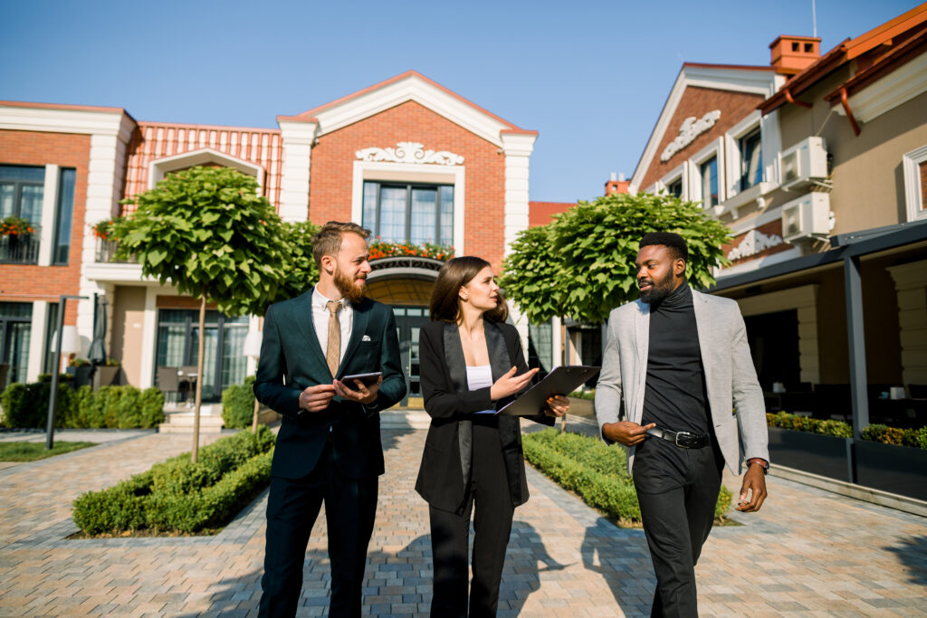 group three young multiracial business people african man caucasian man woman talking each other walking outdoors scaled